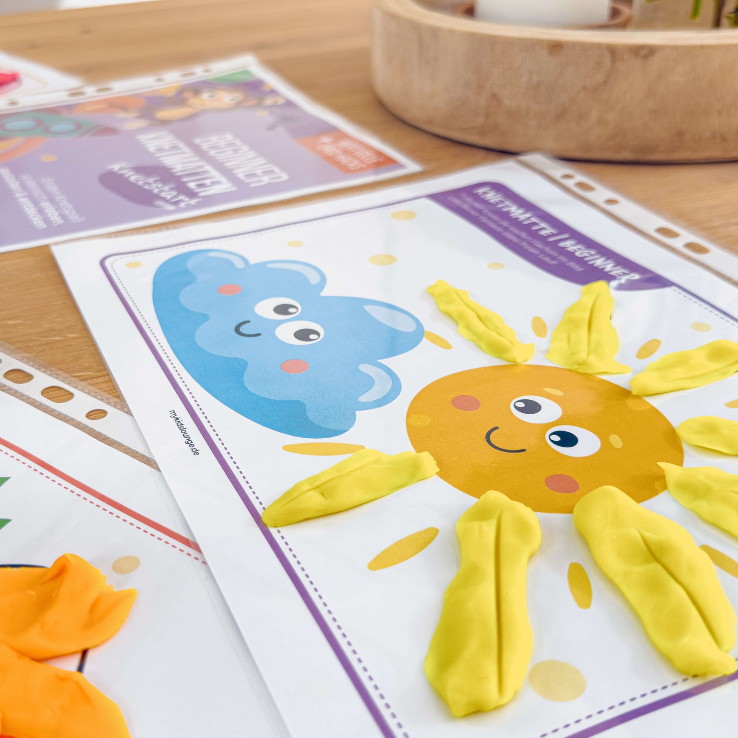 Detailansicht einer Beginner Knetmatte von mykidslounge mit lachender Sonne und Wolke – die Sonnenstrahlen wurden mit Knete geformt, ideal für feinmotorische Übungen.