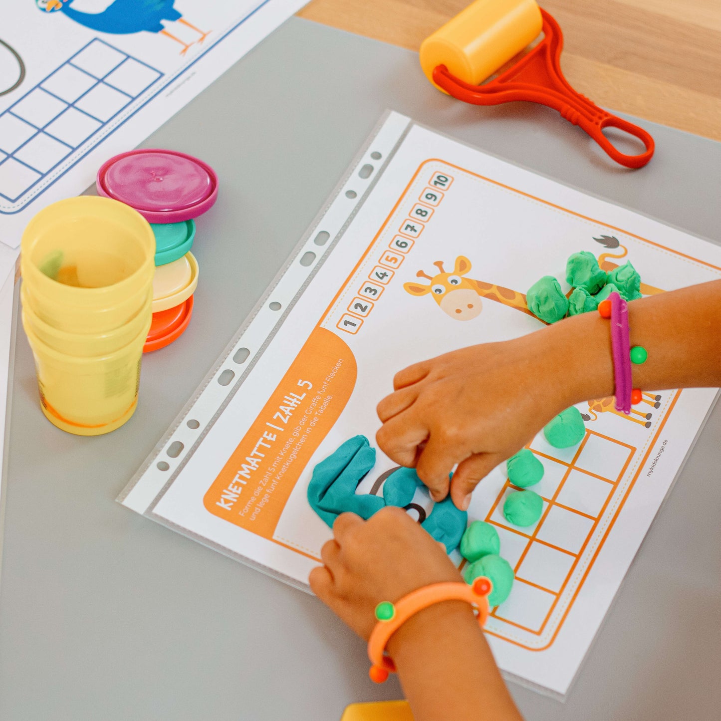 mykidslounge Knetmatte Zahl 5 mit Giraffe. Kinder formen spielerisch Zahlen und Mengen mit Knete – ideal zur Förderung von Motorik und Zahlenverständnis.