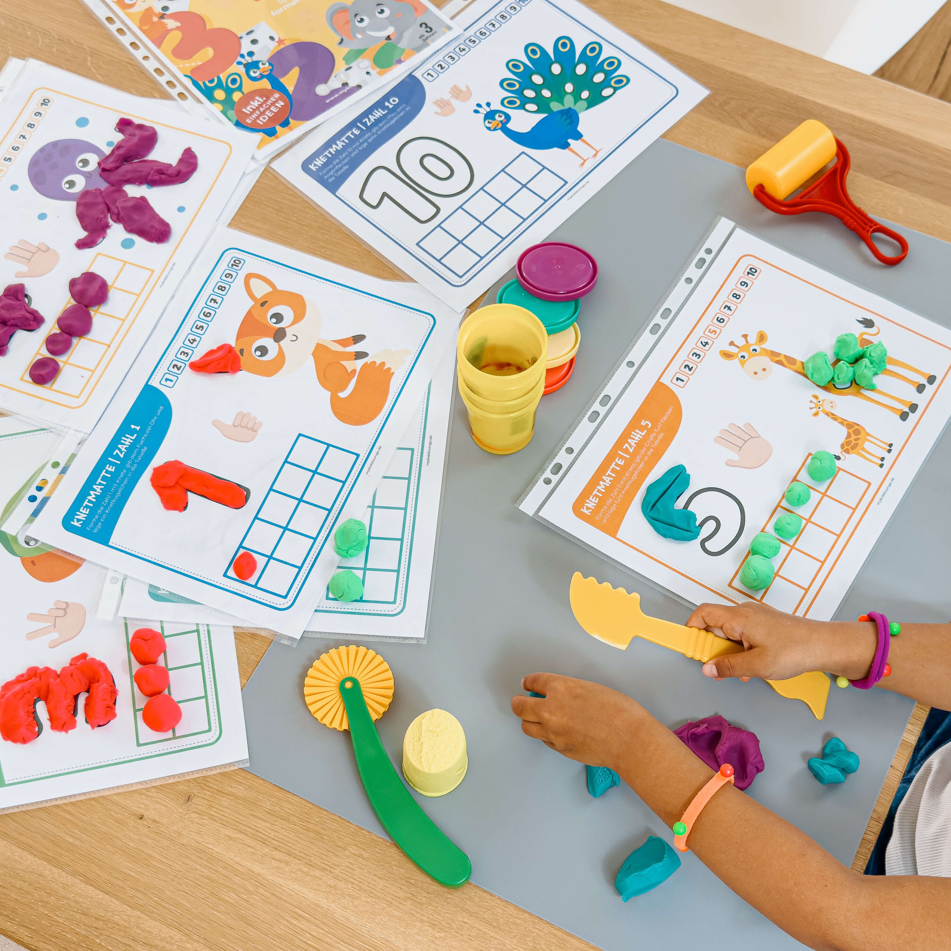 Bunte Zahlen-Knetmatten von mykidslounge im Einsatz. Kinder gestalten spielerisch die Zahlen 1 bis 10 mit Knete – perfekte Förderung von Zahlverständnis und Feinmotorik.