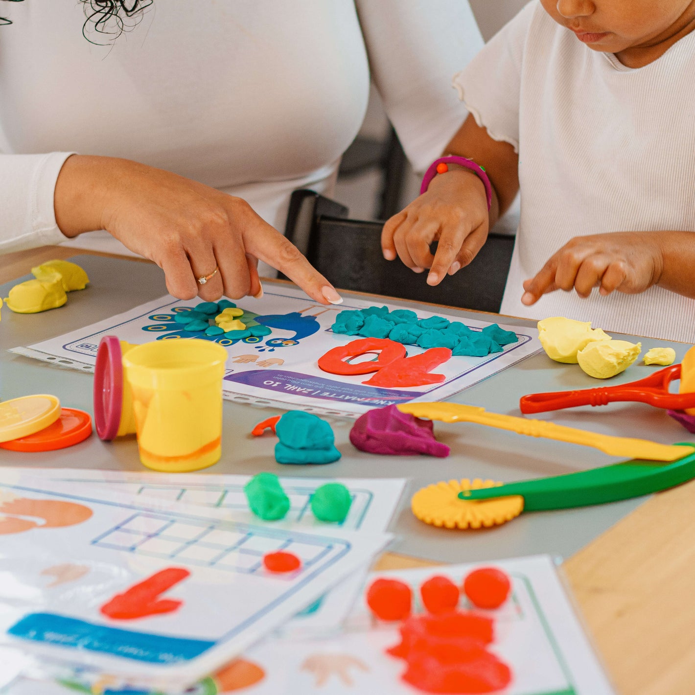 Gemeinsames Lernen mit mykidslounge Knetmatten. Mama unterstützt ihr Kind beim spielerischen Formen und Zählen der Zahl 10.