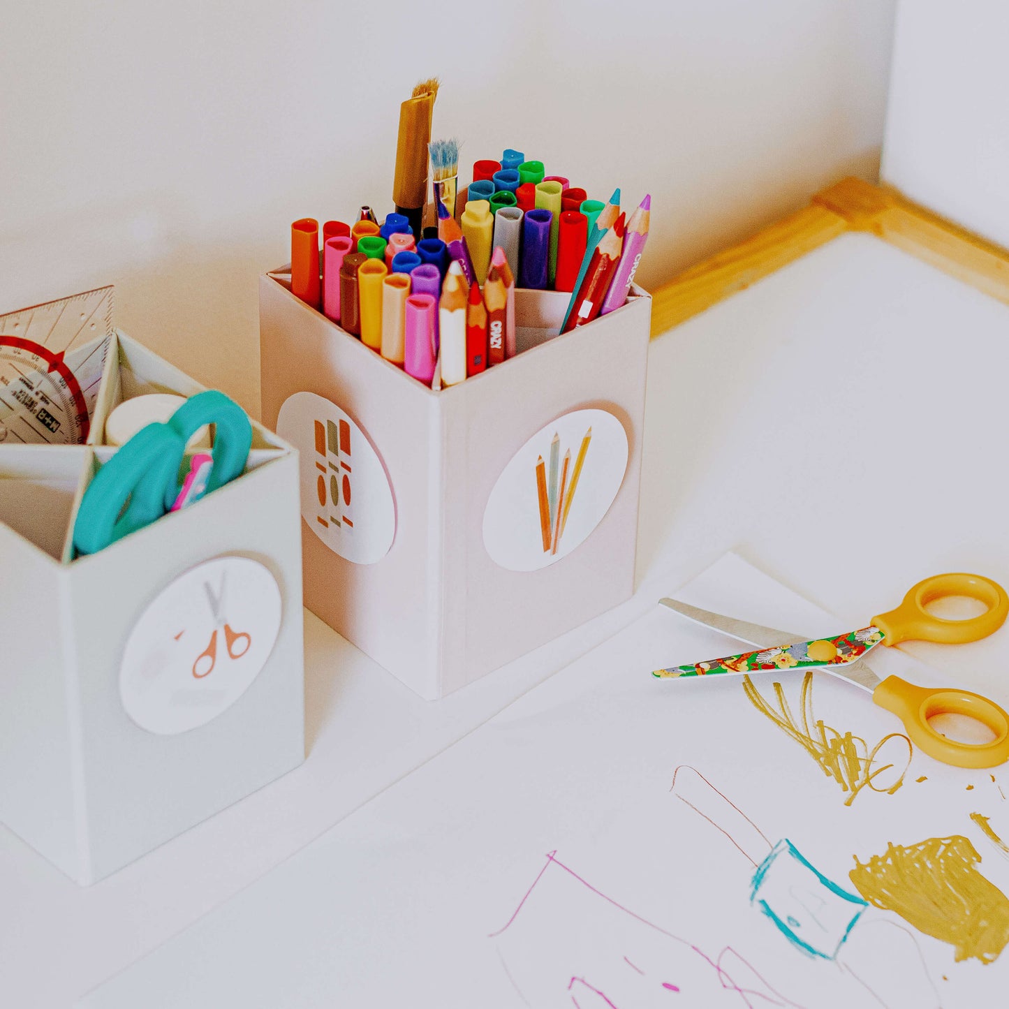 DIY Spielzeuglabel sind an Stifthalterboxen am Kinderschreibtisch angebracht