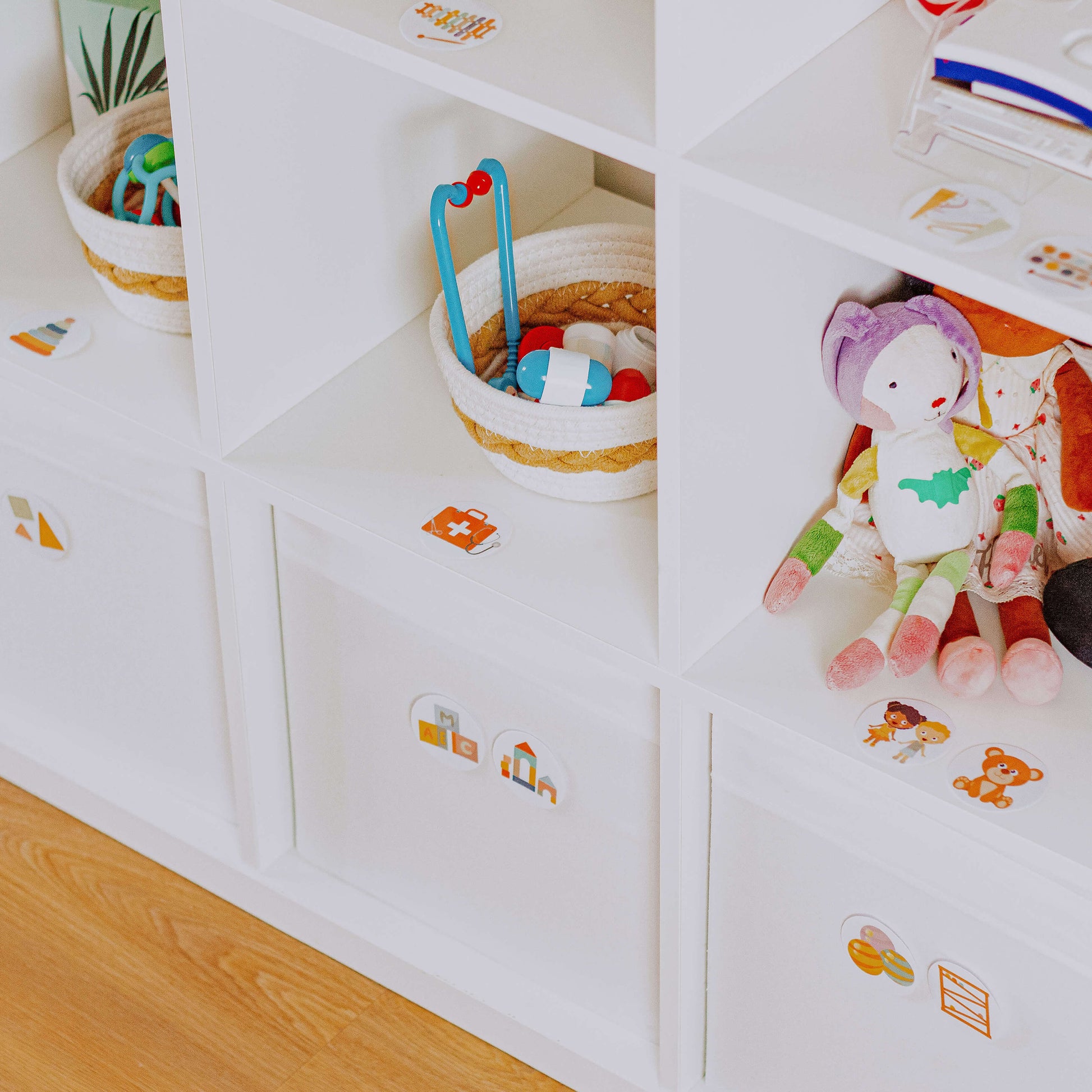 DIY Spielzeugetiketten für Kinder kleben an weißem Spielzeugregal im Kinderzimmer