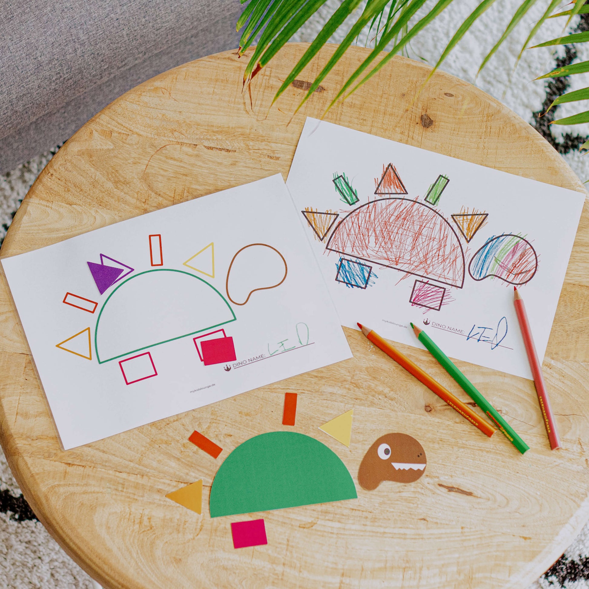 mykidslounge Dinosaurier Druckvorlage liegt mit Buntstiften auf dem Tisch